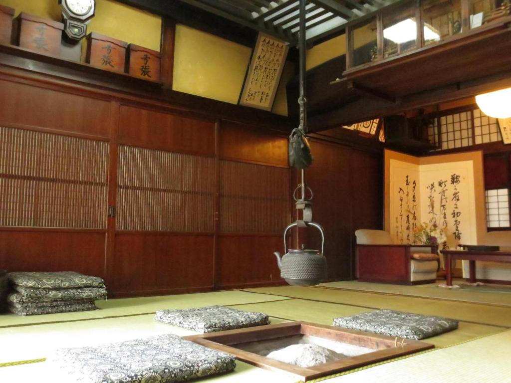a room with two mats on the floor and a hanging lantern at Shitanda in Takayama
