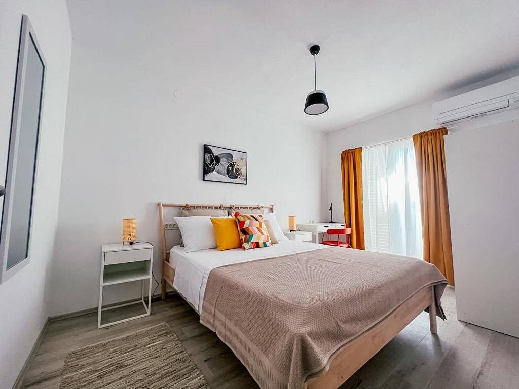 ein Schlafzimmer mit einem großen Bett und einem Fenster in der Unterkunft Apartments Happy in Sukošan