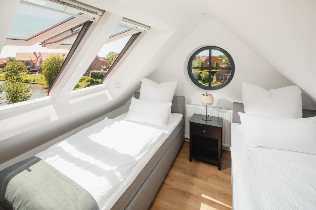 Dormitorio pequeño en el ático con 2 camas y 2 ventanas en Küsten Suite Ost direkte Wasserlage, 2 Balkone, 90qm, en Greetsiel