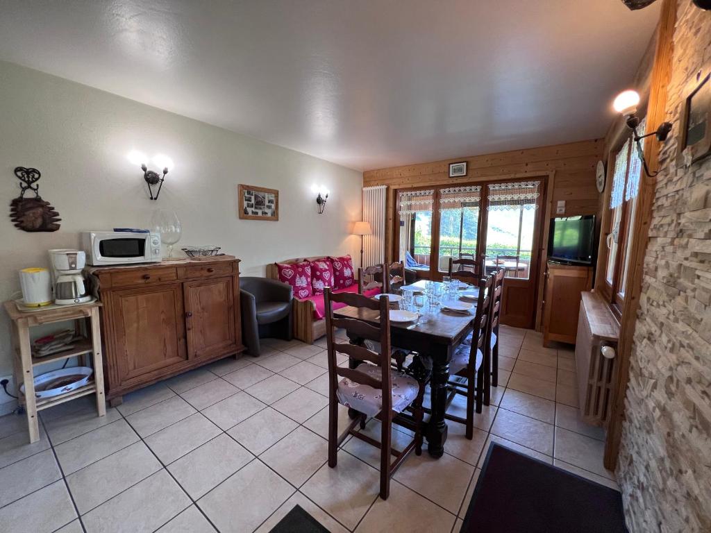 une cuisine et une salle à manger avec une table et des chaises dans l'établissement Petit Lutin - Chalet sur les pistes, à La Clusaz