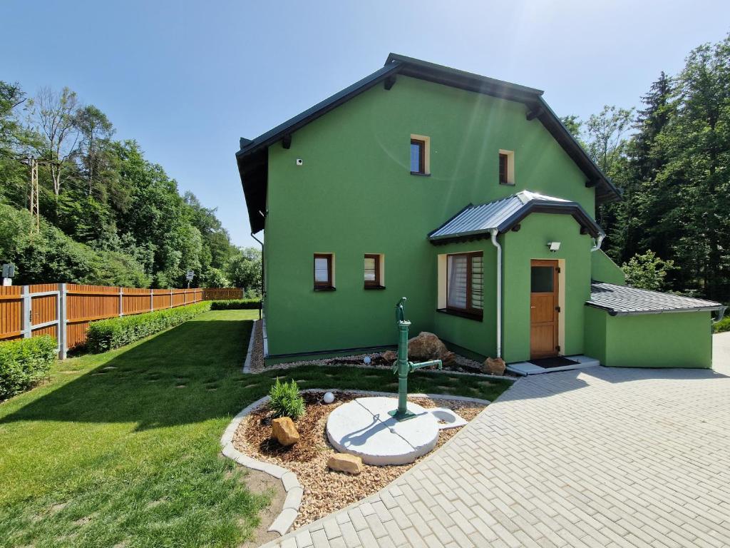 een groen huis met een tuin met een oprit bij Hájenka in Třebívlice