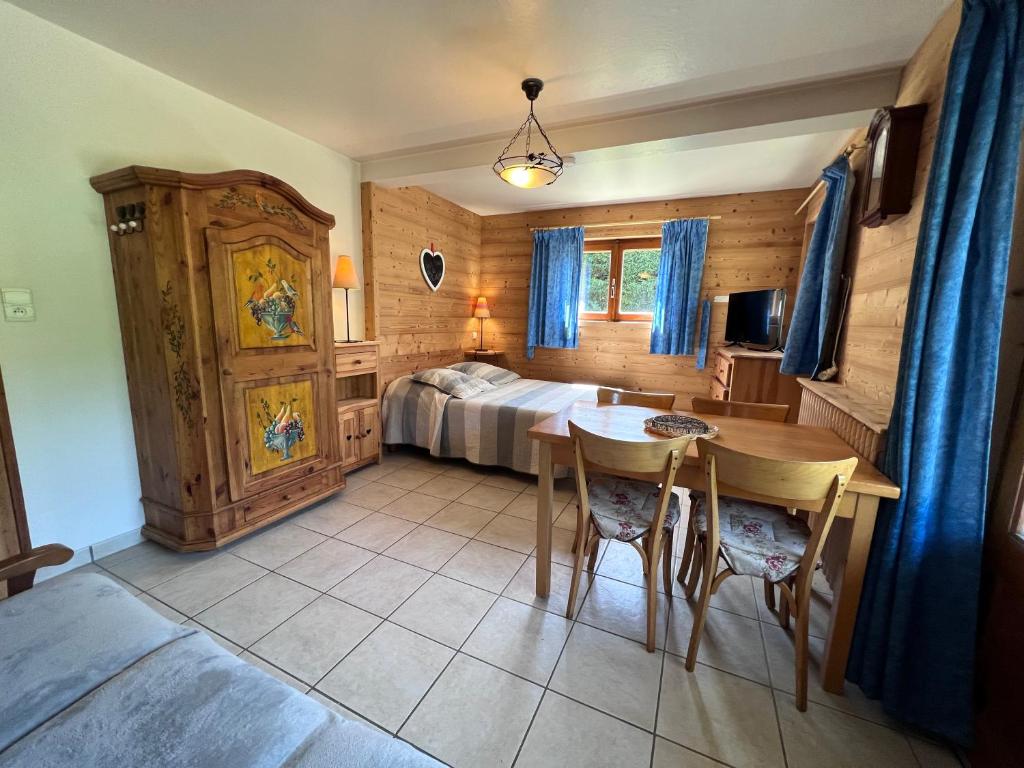 une chambre avec un lit, une table et des chaises dans l'établissement Petit Lutin 1 - Studio dans chalet sur les pistes, à La Clusaz