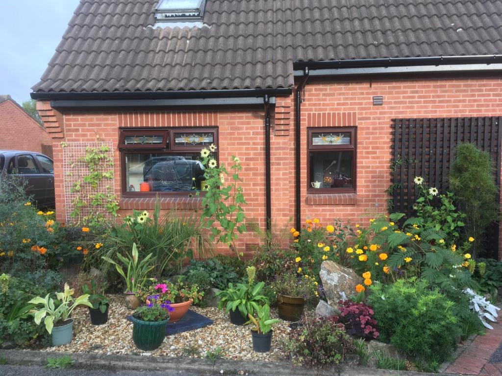 a garden of flowers in front of a house at Self Contained Ground Floor Bedroom with Ensuite Wet room Continental breakfast included Parking for 1 car outside in Heanor