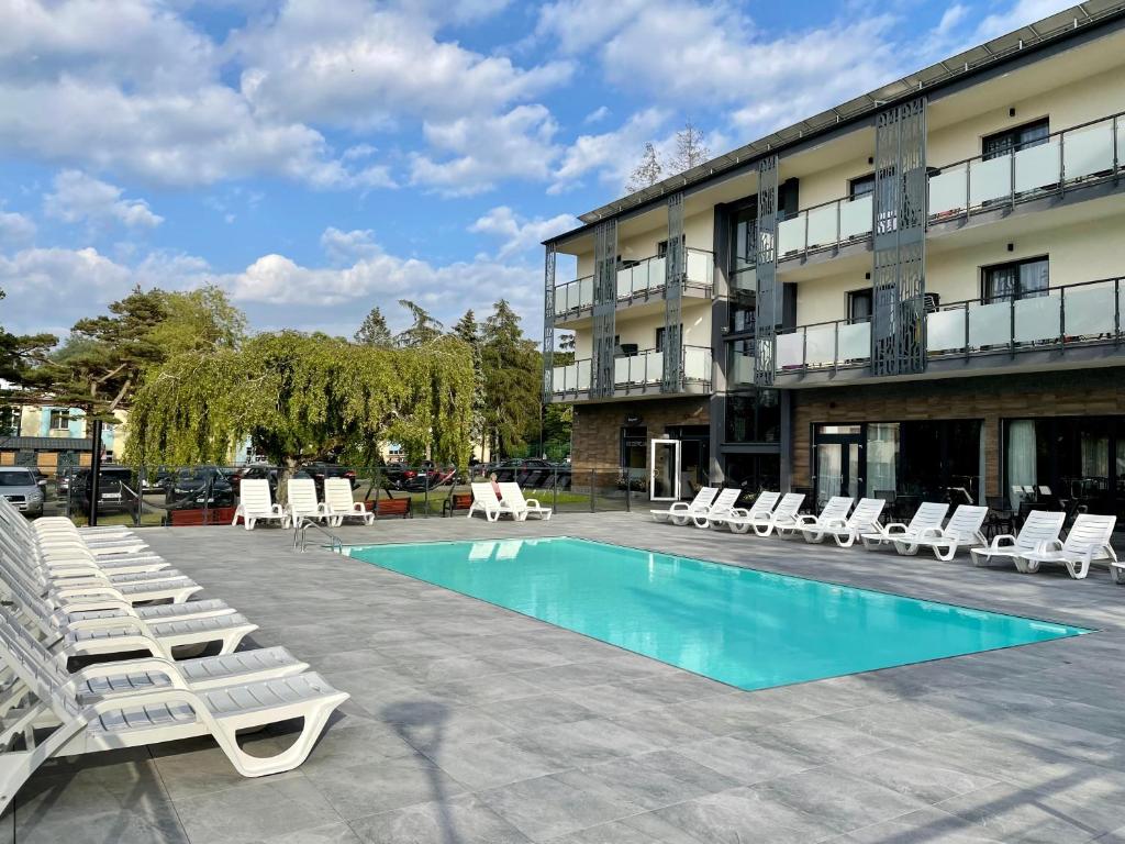 einen Pool mit Liegestühlen und ein Hotel in der Unterkunft Ośrodek Promenada- Horyzont in Jastrzębia Góra