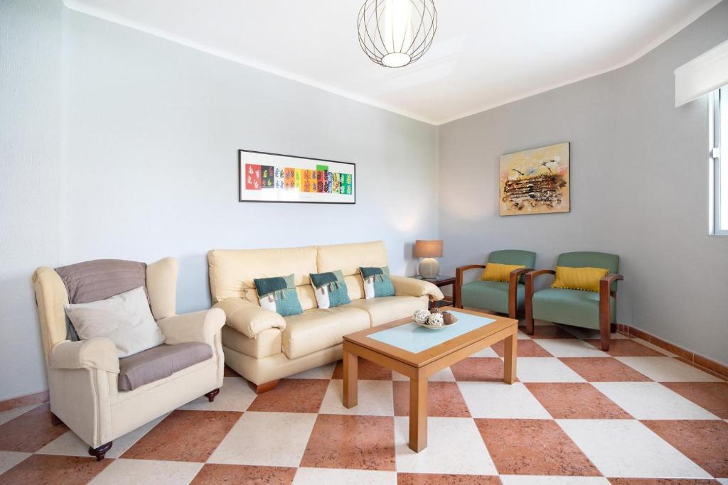 sala de estar con 2 sillas, sofá y mesa en Descanso en Cádiz, en Cádiz
