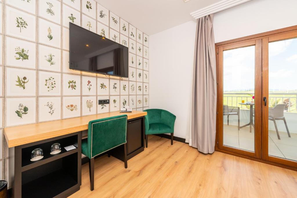 a room with a desk and a television on a wall at Hotel Antonio II in Zahara de los Atunes