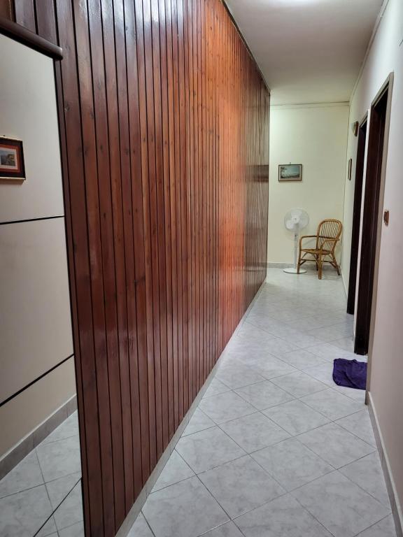 pasillo con puerta de madera, mesa y sillas en Casa Flegrea Napoli, en Quarto