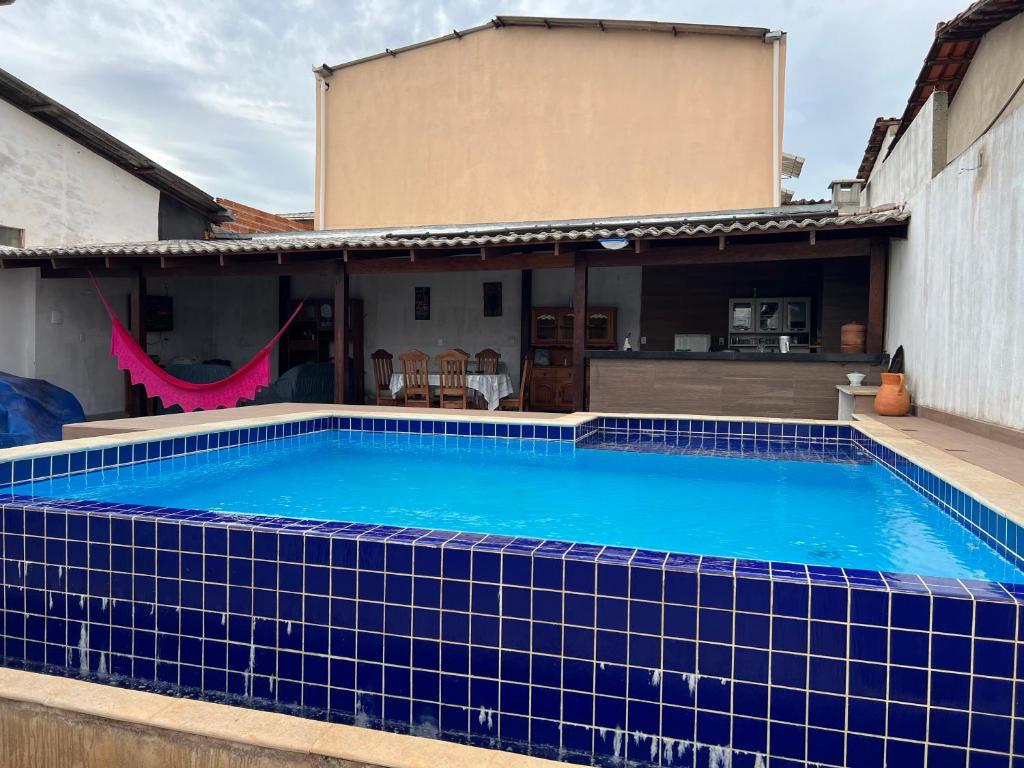 una piscina de azulejos azules frente a una casa en Kasa Bastos, en Pirenópolis