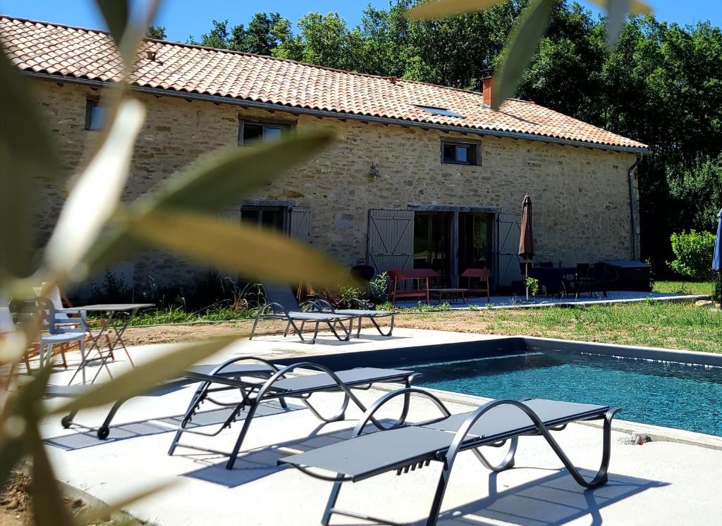 une villa avec une piscine, des chaises et une maison dans l'établissement La Première Vigne, à Puycelci