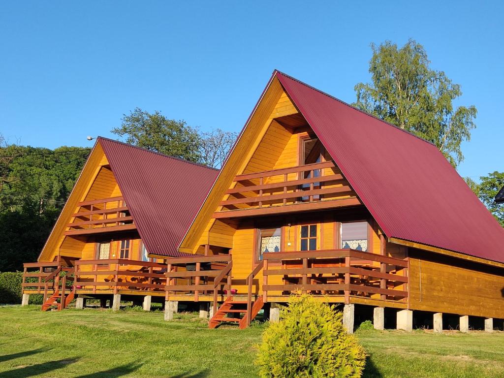 a large wooden house with a red roof at Domki Letniskowe Kama 514 - 280 - 102 in Solina