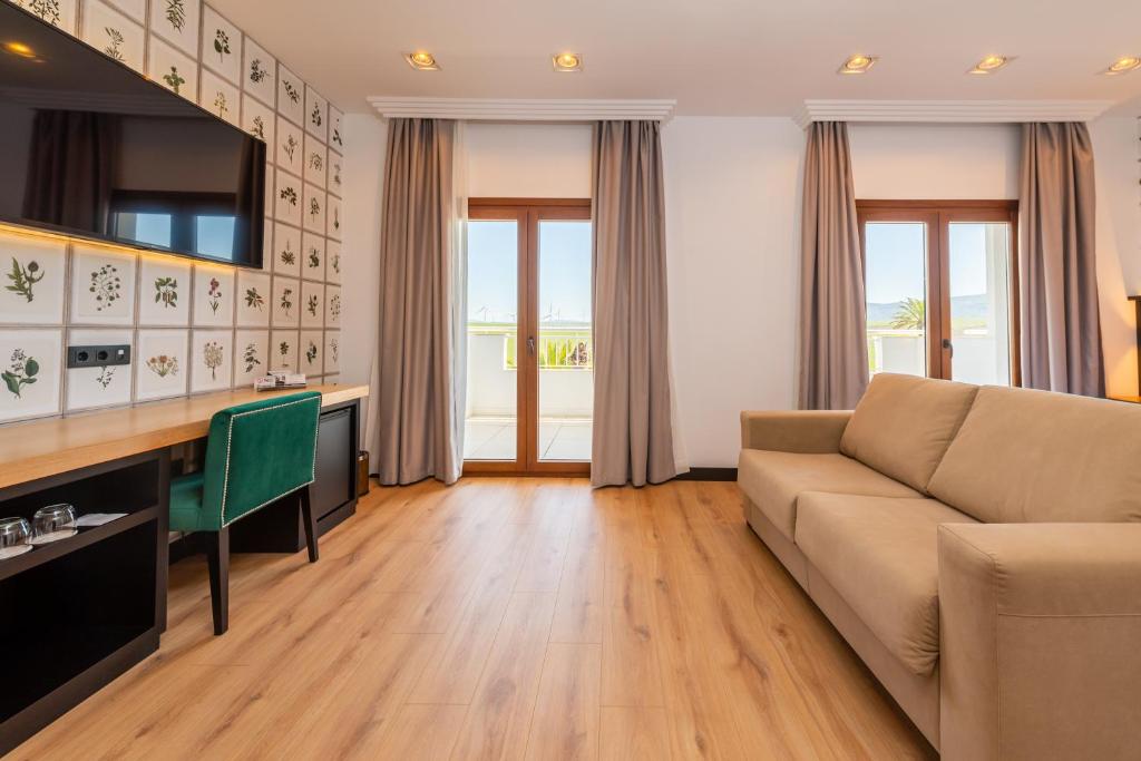 a living room with a couch and a desk at Hotel Antonio II in Zahara de los Atunes