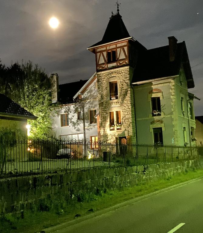 duży zielony i biały budynek z wieżą zegarową w obiekcie AILE DU CHATEAU 6 personnes w mieście Lebétain