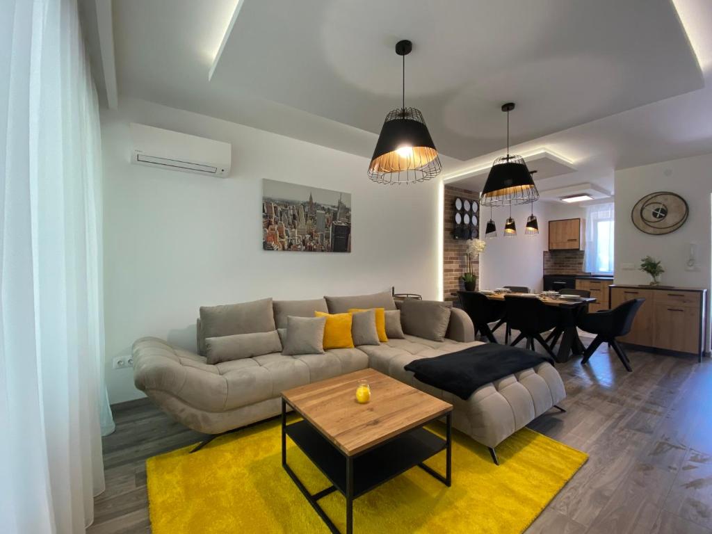 a living room with a couch and a table at Sunshine Homes Zamárdi in Zamárdi