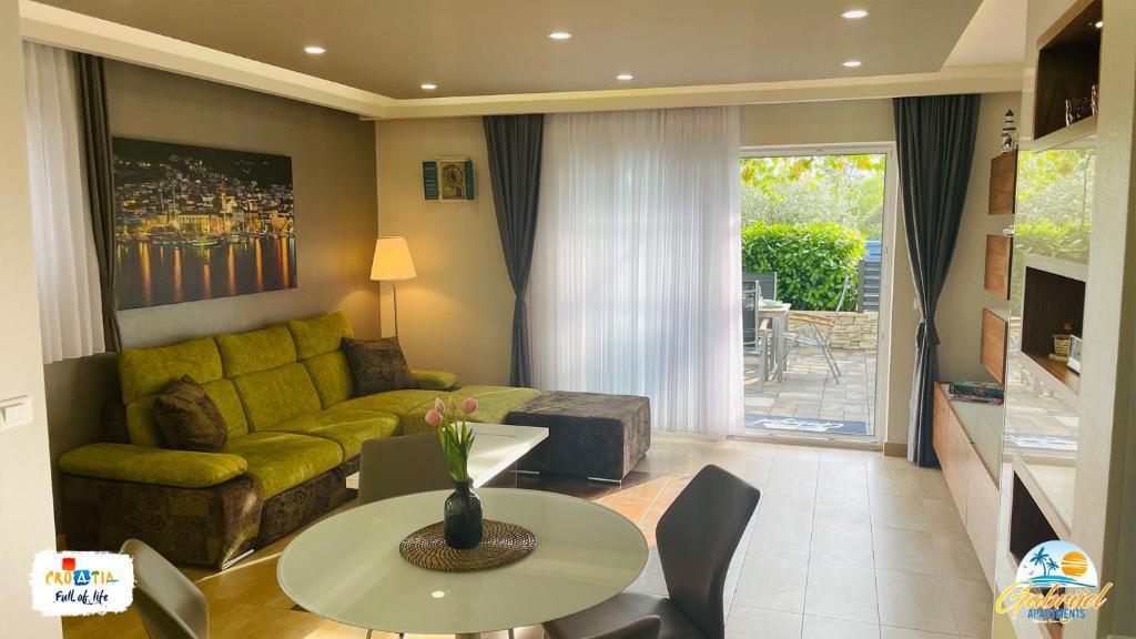 a living room with a couch and a table at Gabrijel Apartments Makarska 1 in Makarska