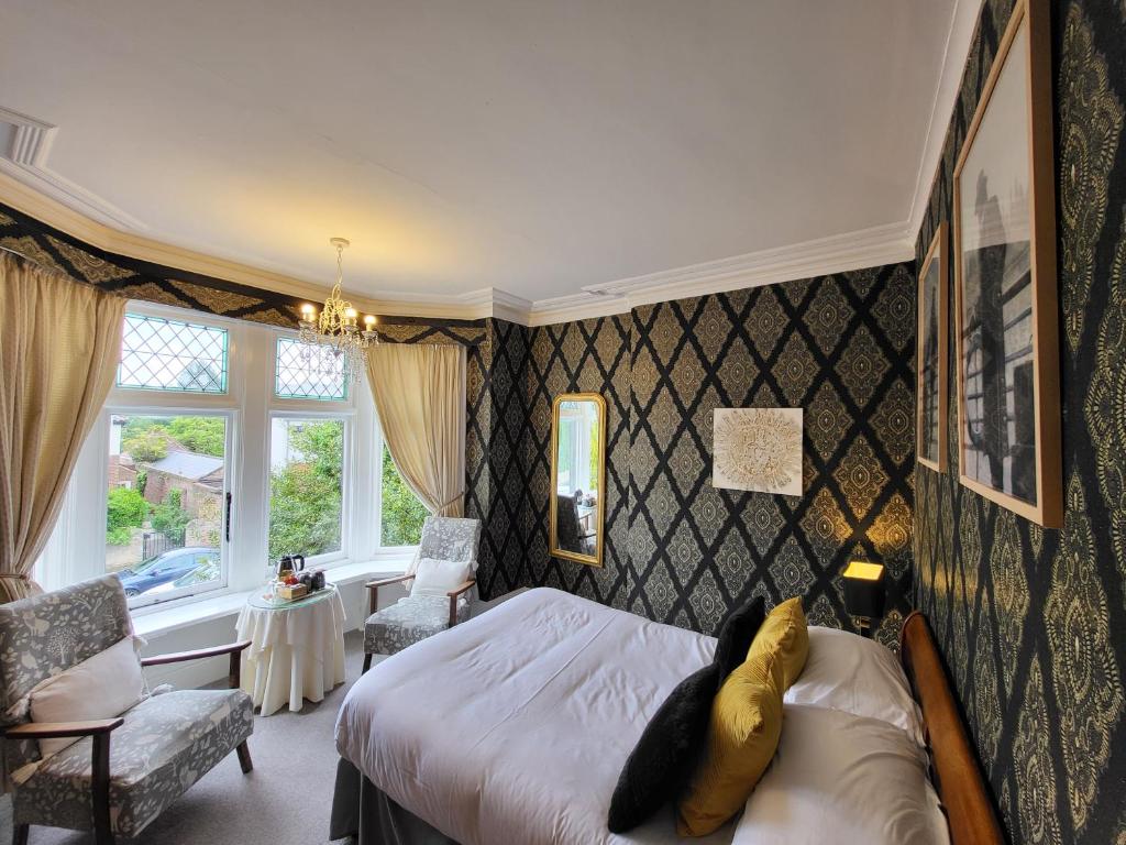 um quarto com uma cama, uma cadeira e uma janela em St George's Guest House em York
