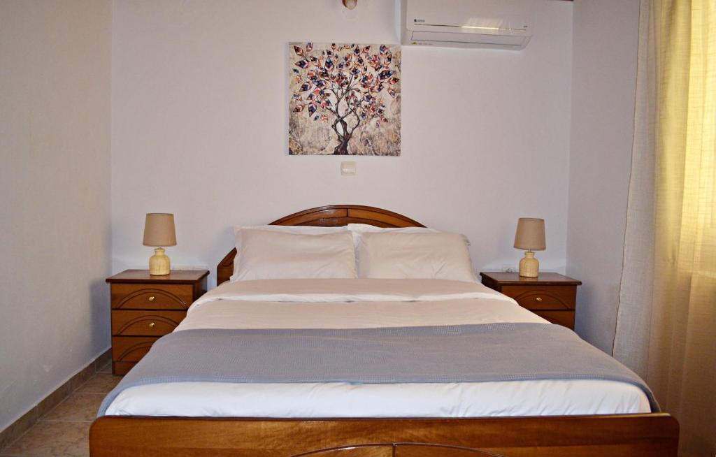 1 dormitorio con 1 cama grande y 2 mesitas de noche en Cozy cottage with garden and olive grove of 5 acr en Mavráta