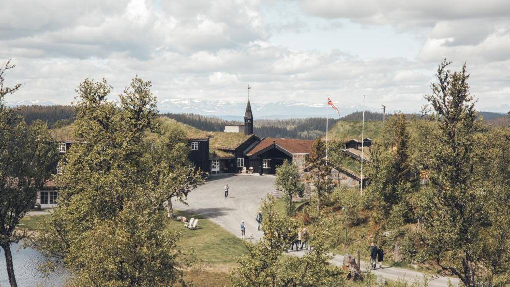 un edificio con una torre de reloj y una iglesia en Danebu Kongsgaard - Boutique Hotel en Aurdal