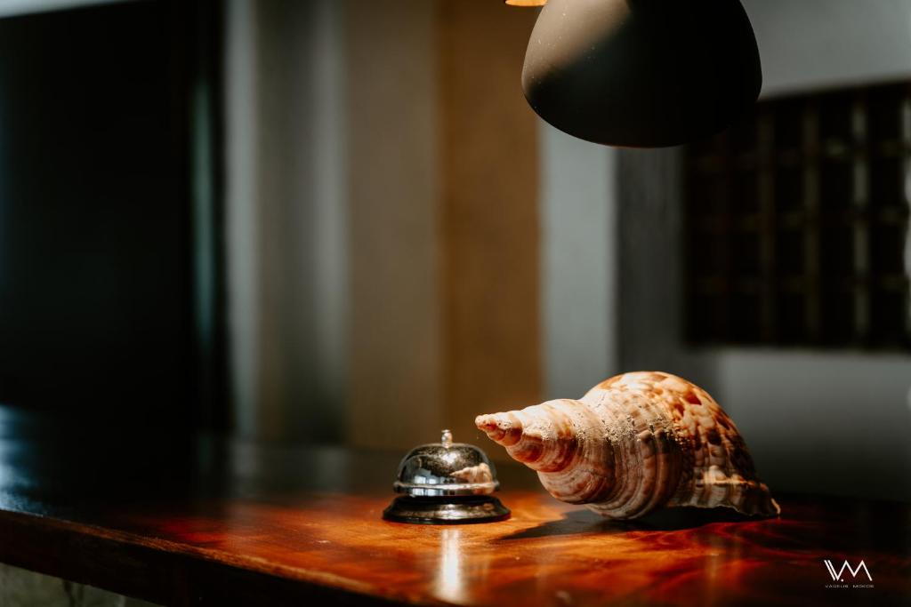 a figurine of a pig on a table next to a bell at Arilla Beach Hotel in Perdika