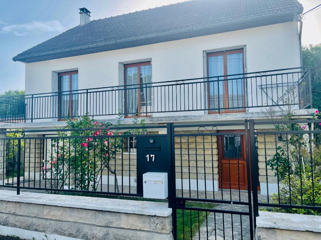 uma casa com uma cerca preta e uma porta vermelha em Super maison entre paris et Disney em Chelles