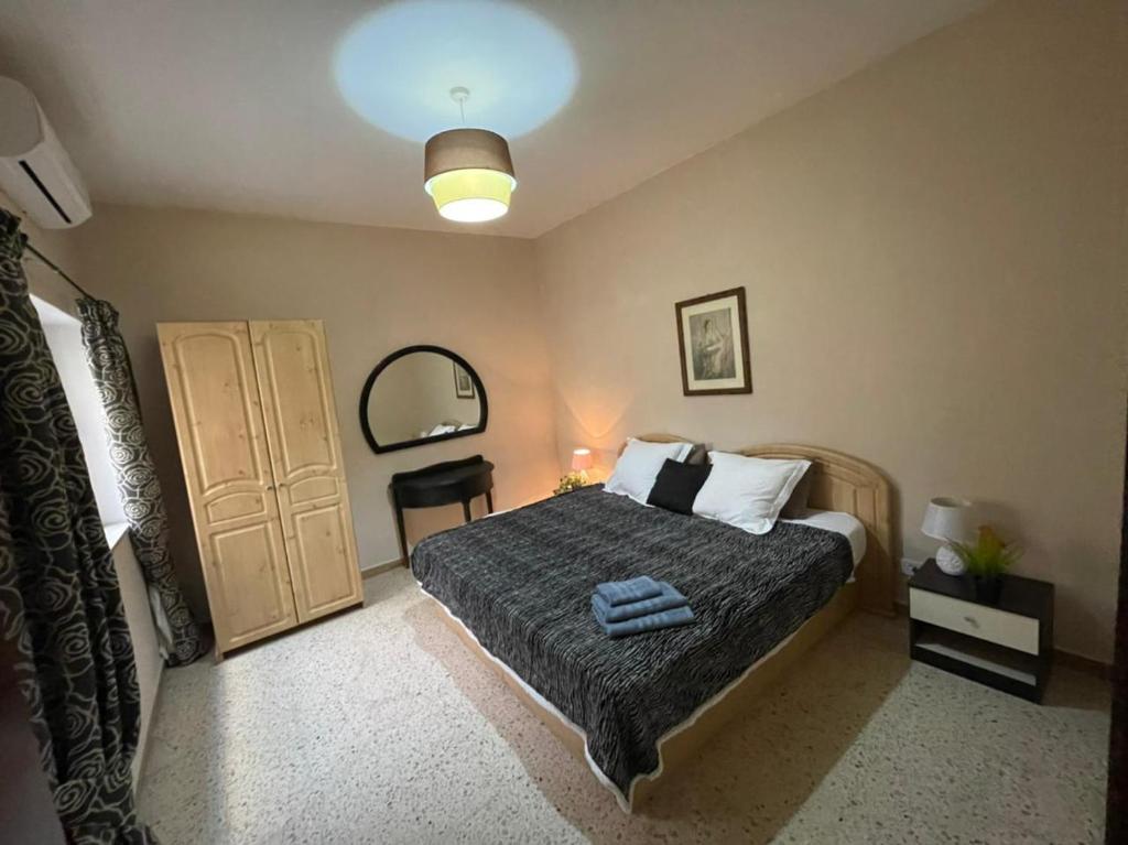 梅利哈的住宿－Olivier House Mellieha，一间卧室配有一张大床和一盏灯