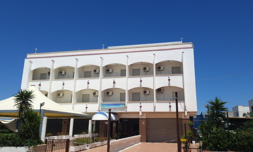 a large white building with balconies on it at Albergo California in Lesina