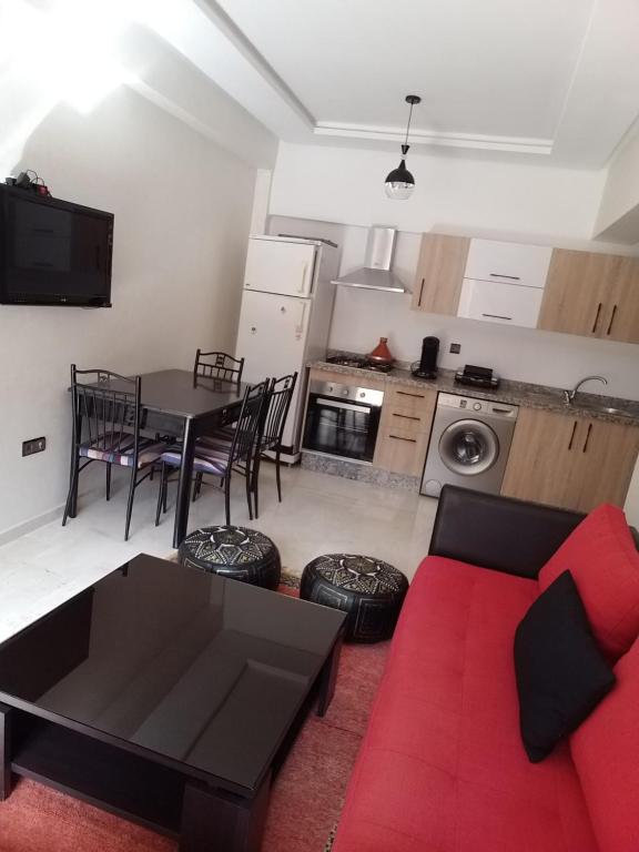 a living room with a red couch and a table at Agréable appartement au coeur de Guéliz, Marrakech in Marrakesh