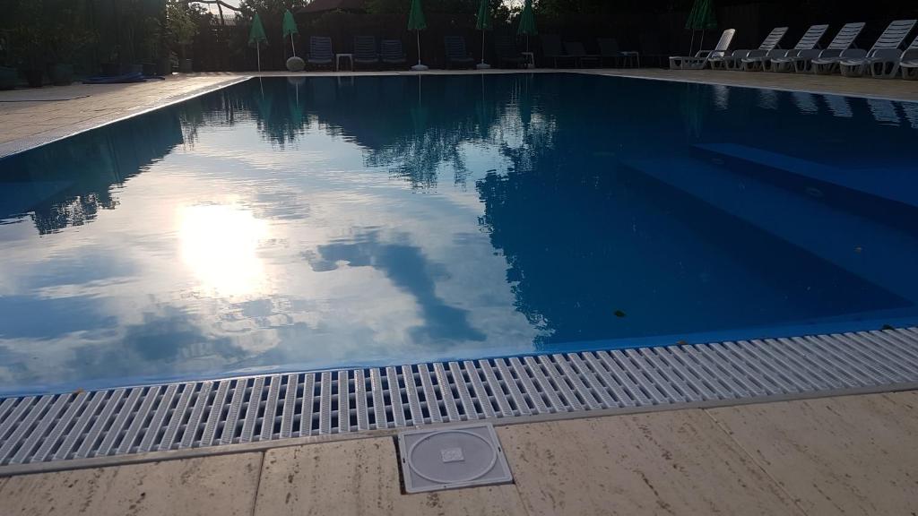 einem Pool mit Spiegelung des Himmels im Wasser in der Unterkunft Anthimos in Baile Felix