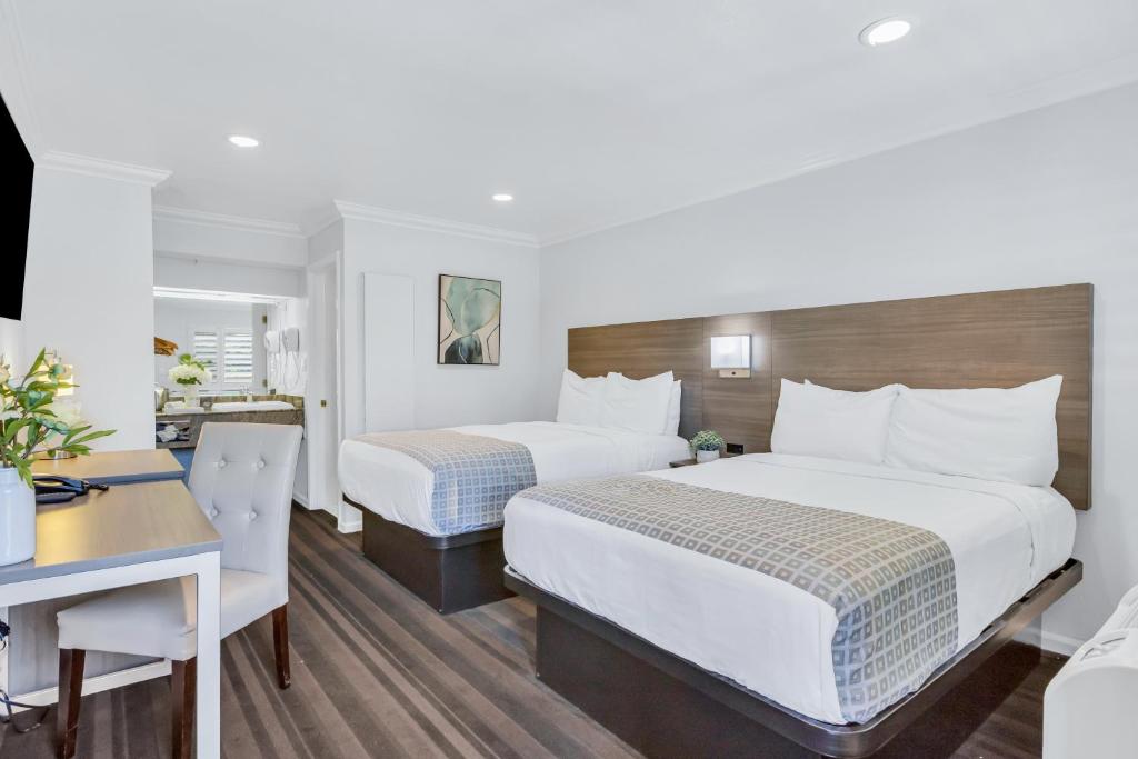 a hotel room with two beds and a desk at Napa Valley Hotel & Suites in Napa
