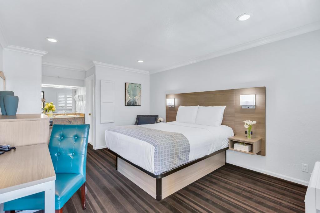 um quarto de hotel com uma cama e uma cadeira azul em Napa Valley Hotel & Suites em Napa