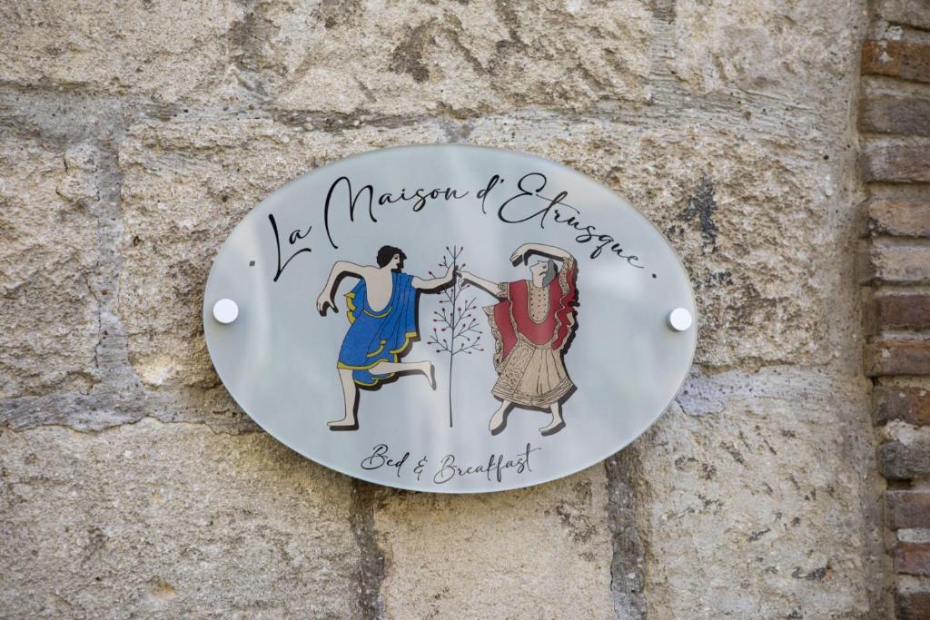 una señal para un museo de vestidos en una pared en La Maison d'Etrusque, en Tarquinia