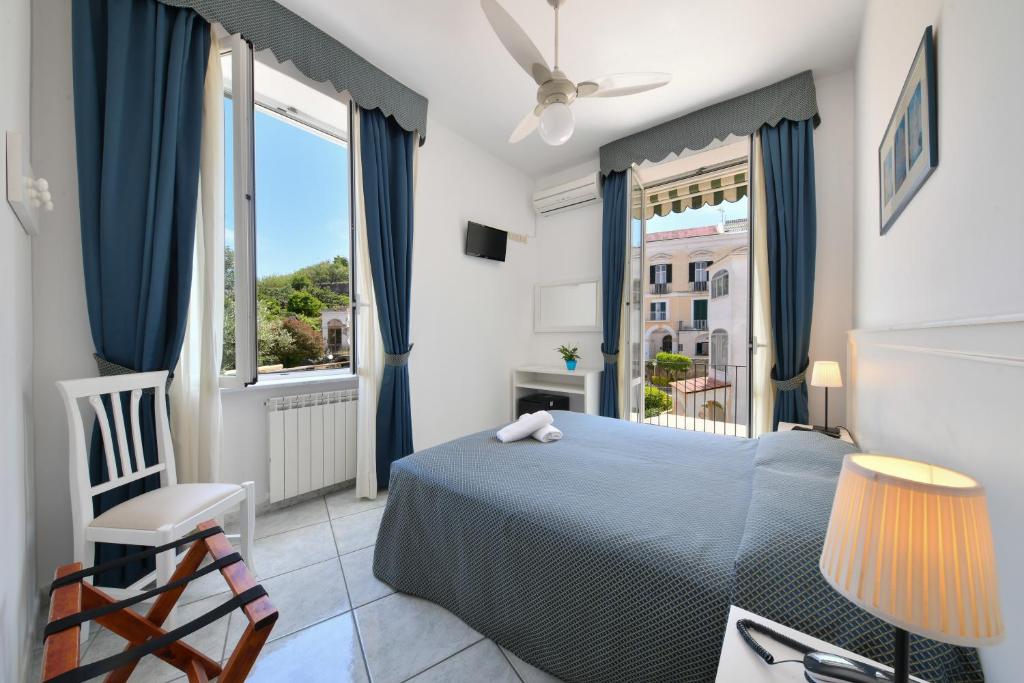 a bedroom with a bed and a large window at Hotel Noris in Ischia