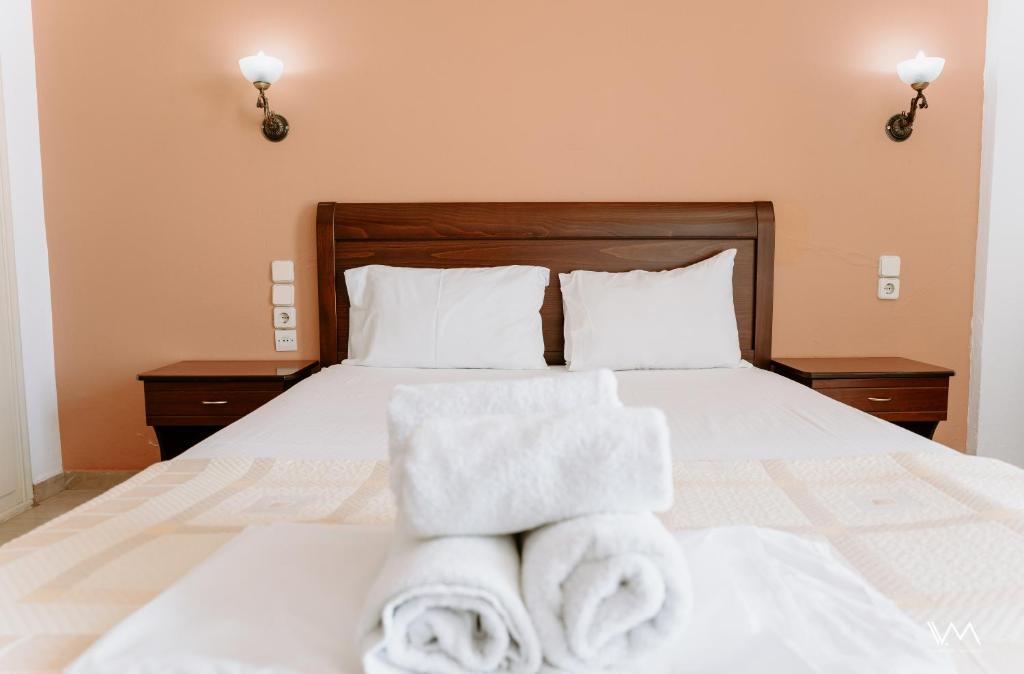 a bedroom with a bed with towels on it at Arilla Beach Hotel in Perdika