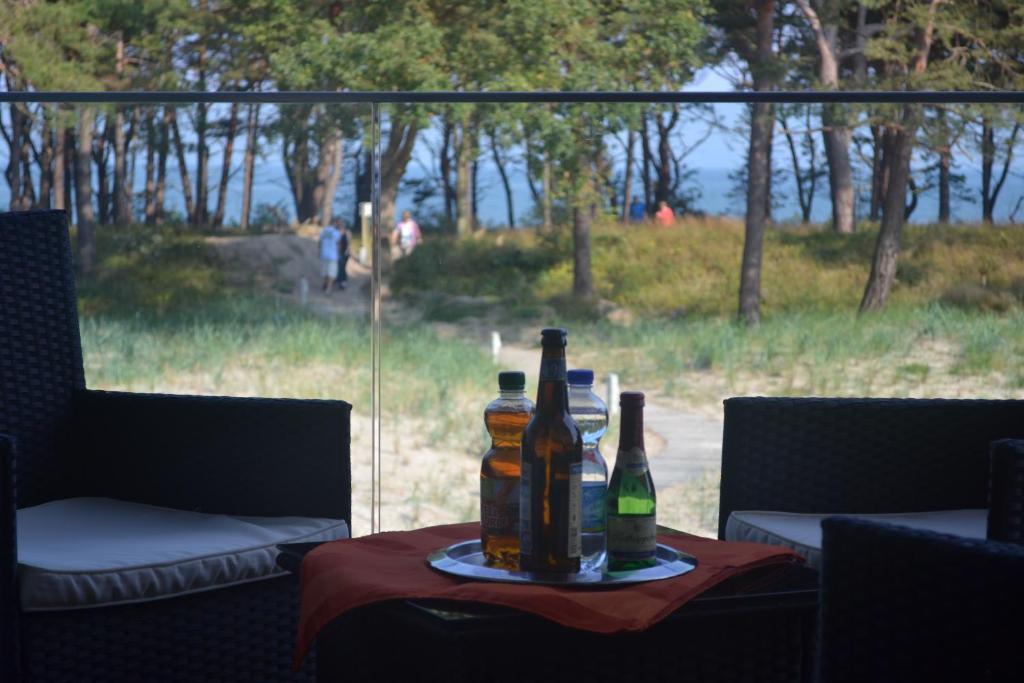two bottles of beer on a table in front of a window at Apartment mit Meeresblick in Binz