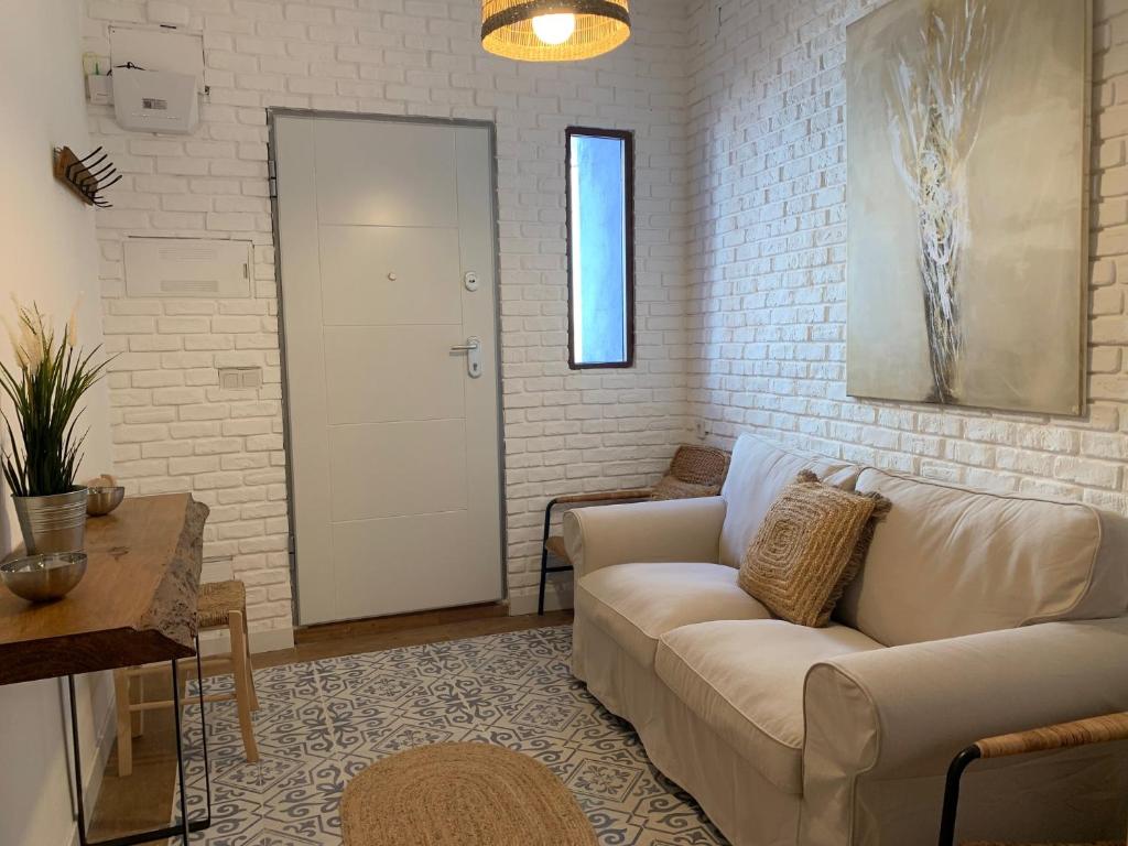 a living room with a couch and a white brick wall at Home SEA&DREAMS OldTown III in Calpe
