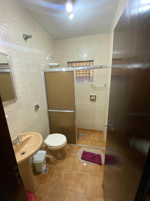 a bathroom with a toilet and a sink at Casa para alugar em Bertioga - Piscina, Wifi e Churrasqueira in Bertioga