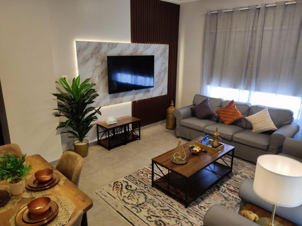 العبير شقة فندقية في King Abdullah Economic City: غرفة معيشة مع أريكة وطاولة