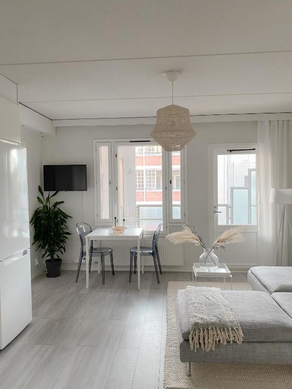 a white living room with a table and a couch at Modern one bedroom Apartment with Sauna near Airport in Vantaa