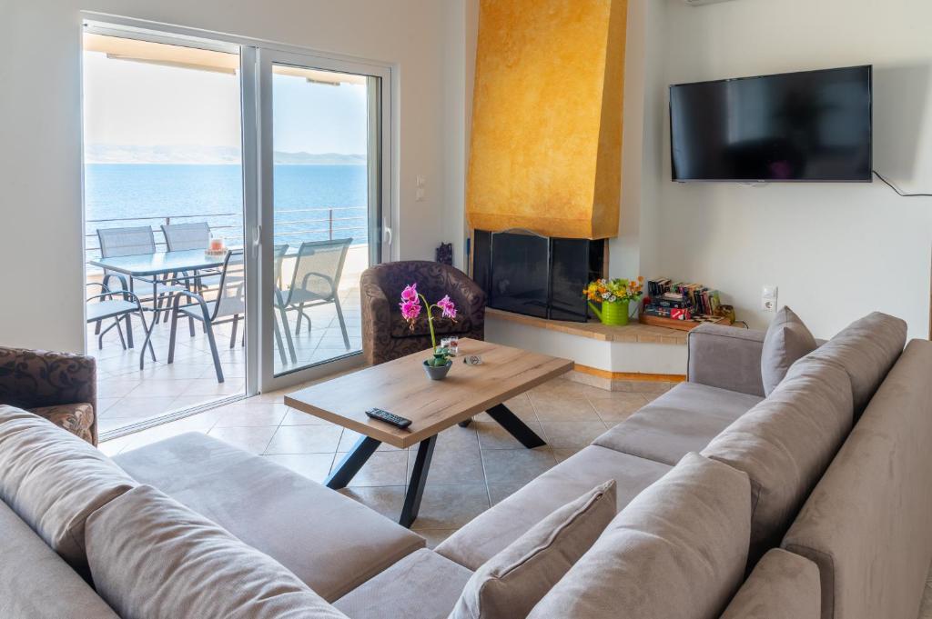uma sala de estar com um sofá e uma mesa em Blue Horizon View em Lávrion