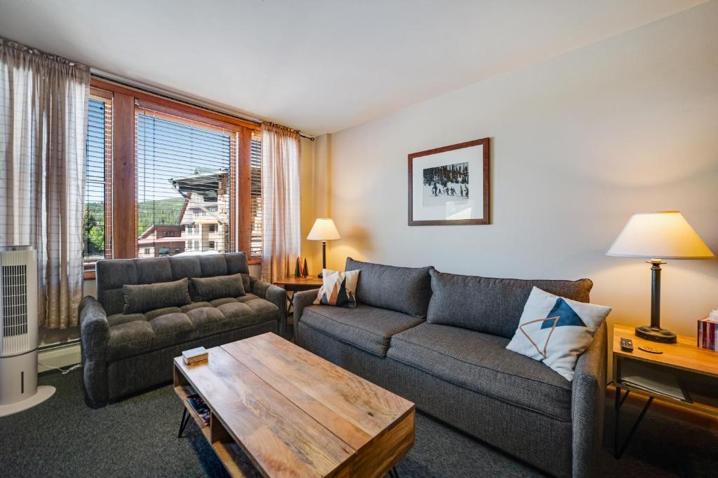 a living room with a couch and a table at Zephyr Mountain Ski-In Ski-Out Condo in Winter Park