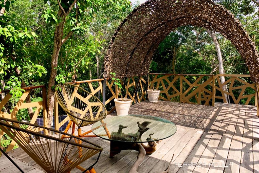 a table and chairs sitting on a wooden deck at Bufo Alvarius in Tulum