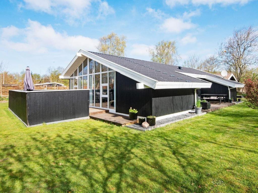 ein schwarzes Haus mit einem großen Hof in der Unterkunft 6 person holiday home in Hemmet in Falen