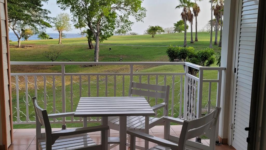 d'une table et de chaises sur un balcon avec vue sur un parcours de golf. dans l'établissement DESIRADE 18 sainte luce, à Sainte-Luce