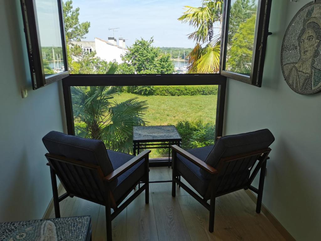 two chairs and a table in a room with a window at DOM LORON in Poreč