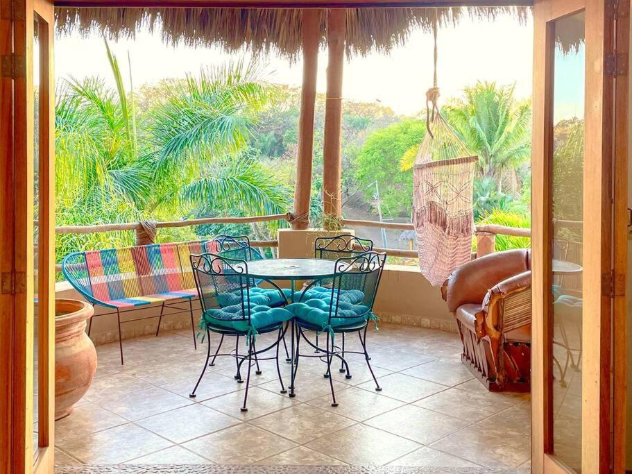 a balcony with a table and chairs in front of a window at Casa Boho 2 in Sayulita