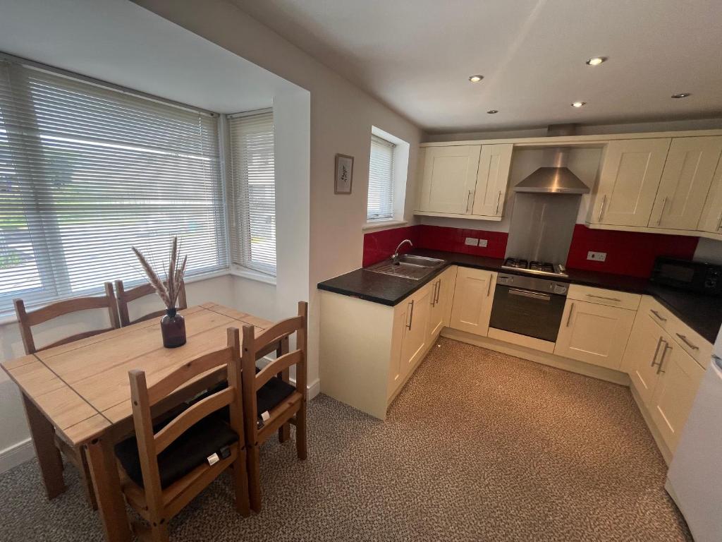 a kitchen with a wooden table and a dining room at SUPER 4 Bedroom 9 Person 3 Bathroom MEGA HOUSE in Hull