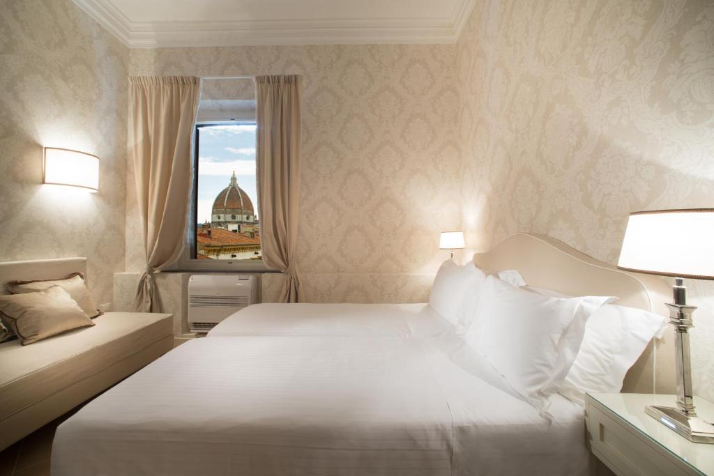 sypialnia z białym łóżkiem i oknem w obiekcie San Giuliano Inn we Florencji