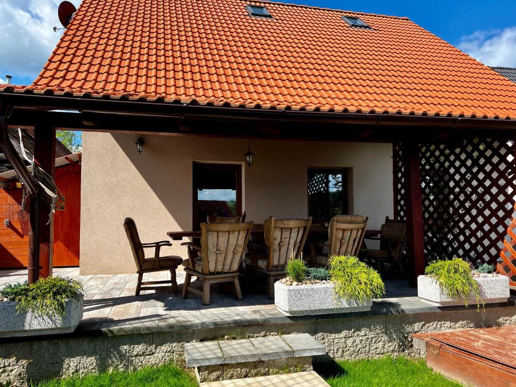 un patio con sillas y una mesa con techo naranja en Chalupa Kadov, en Sněžné