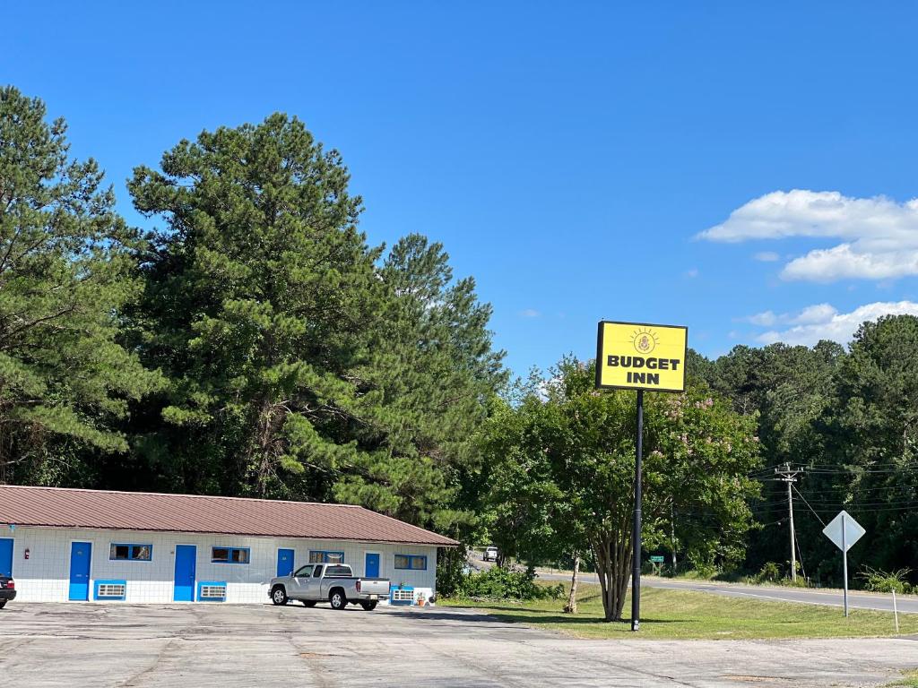 una señal amarilla delante de un edificio con un camión en Budget Inn Decatur Priceville, en Decatur