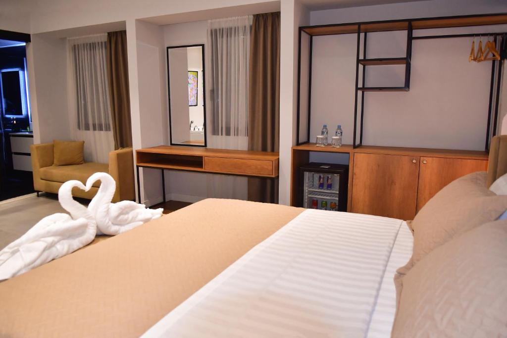 ein Schlafzimmer mit einem Bett mit einem Schwan darauf in der Unterkunft 313 Villa Boutique Hotel City Center in Tirana