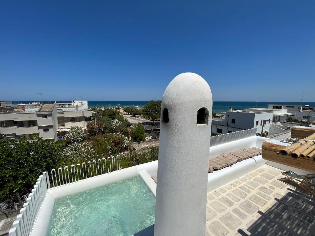 a swimming pool next to a white pole on a balcony at Casa Mediterranea Jacuzzi riscaldata con Caminetto in Specchiolla